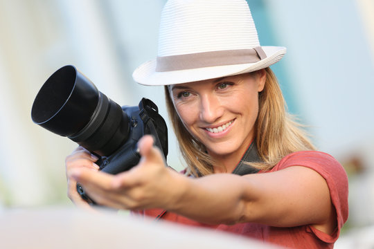 Woman photographer taking picture of model outside