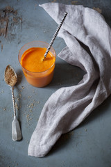 orange carrot smoothie with spoon of brown sugar