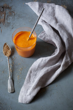 orange carrot smoothie with spoon of brown sugar
