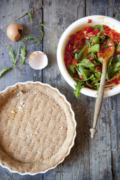 making a wholemeal quiche with red peppers and rocket on mold