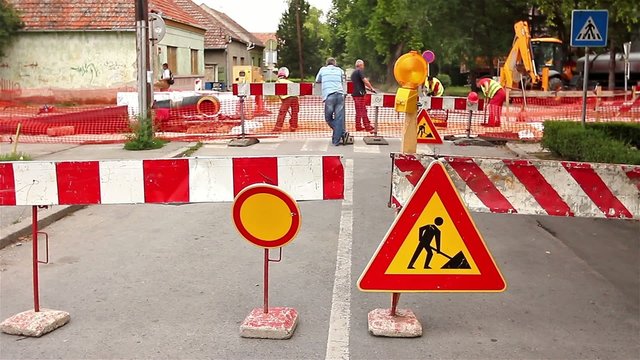 Road signs in a street, under reconstruction symbol
