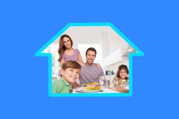 Composite image of family looking at the camera at dinner time