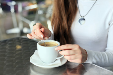 Female hands stirred the coffee in the cup