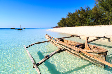 Traditional fisherman boat lying near the beach in clear water