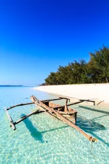 Keuken foto achterwand Zanzibar Traditionele vissersboot die dichtbij het strand in helder water ligt