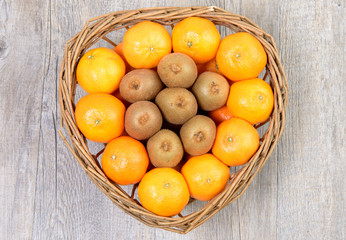 tangerins and kiwi fruit in a wicker basket