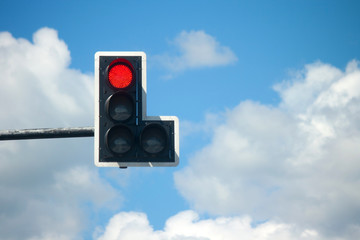 Red light traffic lights against blue sky background.