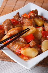 Asian pork meat with pineapple on a plate close-up. Vertical