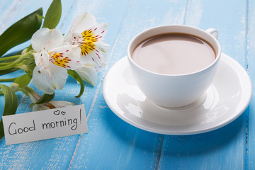Cup of coffee and alstroemeria flowers on the wooden table