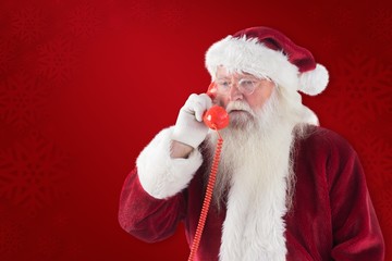Composite image of santa on his red phone