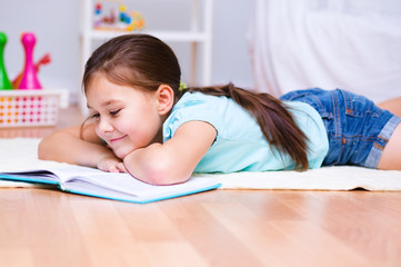 Little girl is reading a book