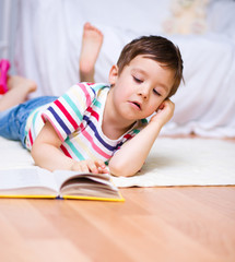 Little boy is reading a book
