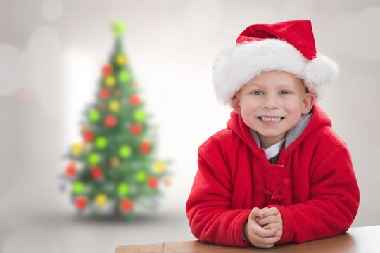 Composite image of cute boy in santa hat