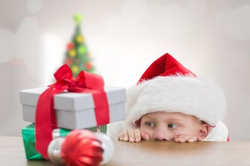 Fototapeta na wymiar Composite image of cute boy looking at gifts