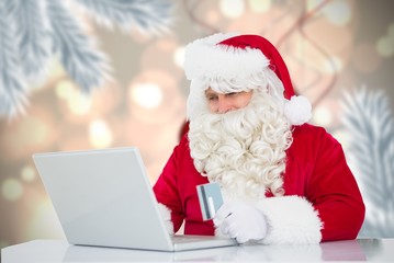Composite image of santa using laptop