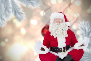 Composite image of santa claus sitting in lotus pose