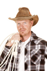 cowboy holding rope over shoulder looking close