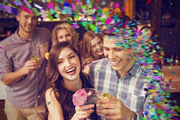 Obraz na płótnie Canvas Composite image of happy friends drinking cocktails together