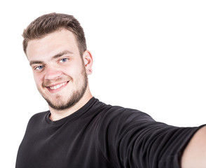 Obraz premium Happy young man taking a selfie photo on white background