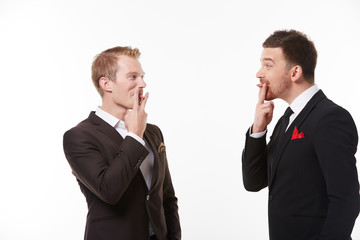 Two young men in suits talking having fun
