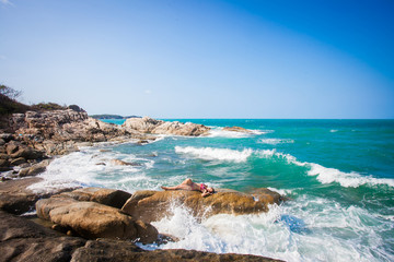 Young sexy woman in red bikini posing In front of sea on the