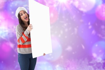Excited brunette in santa hat showing white poster