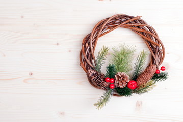 Christmas wreath of twigs with pine needles and cones on light b