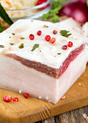 salted lard and spices on wooden surface