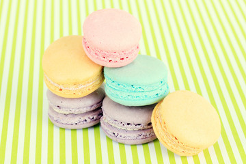 Tasty macaroons on green striped background