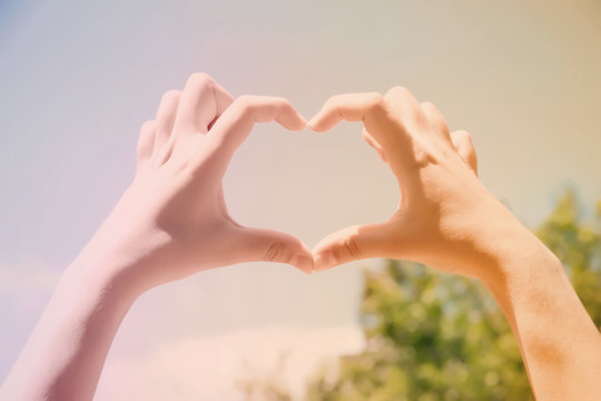 Young woman holding hands in heart shape framing