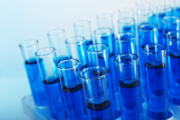 Blue water in a transparent test-tube on light background