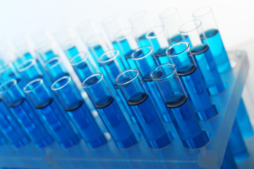 Blue water in a transparent test-tube on light background