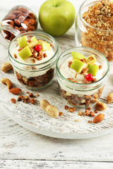 Healthy layered dessert with muesli and fruits on table