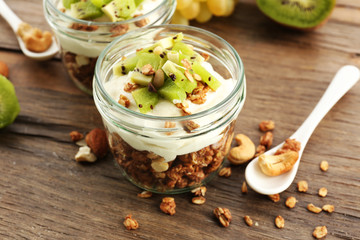 Healthy layered dessert with muesli and fruits on table