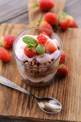 Healthy layered dessert with muesli and berries on table