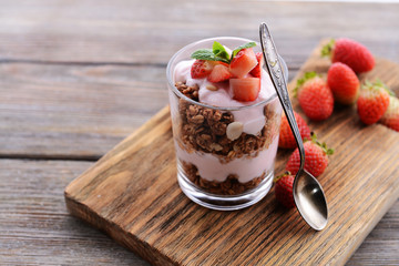Healthy layered dessert with muesli and berries on table