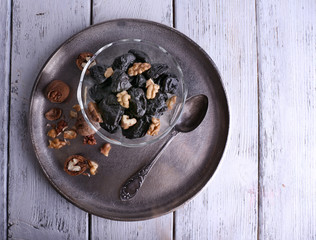 Metal tray with glass bowl of prunes and walnuts, shell and