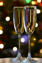 Two champagne glasses on table, on fir-tree background