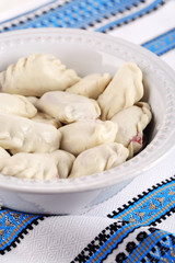 Vareniki with cherry in bowl on tablecloth close-up