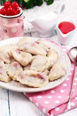 Vareniki with cherry on plate on tablecloth close-up