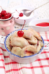 Vareniki with cherry in pan on tablecloth close-up