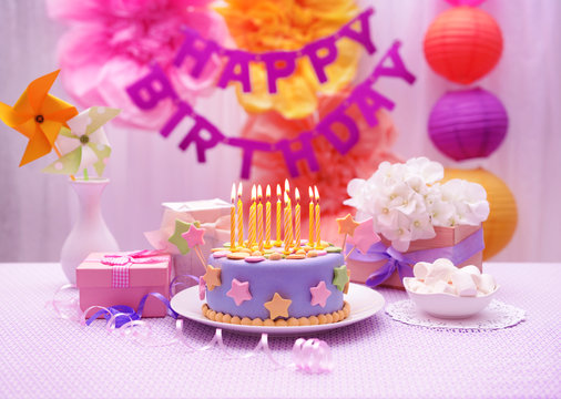 Delicious birthday cake on table on bright background