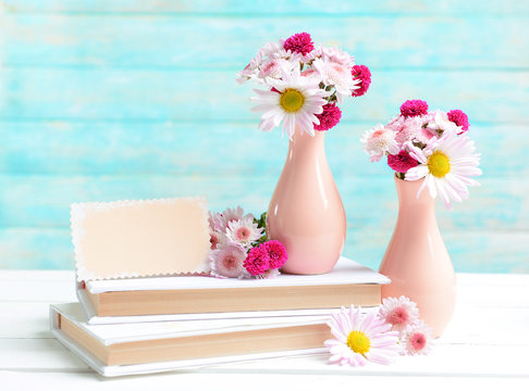 Fototapeta Beautiful flowers in vases on table on light blue background