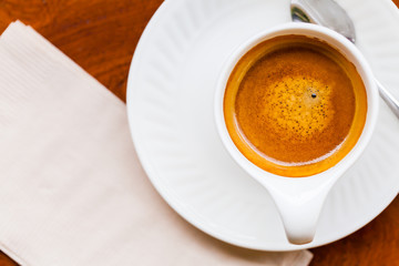 Cup of fresh espresso with spoon, napkin on table