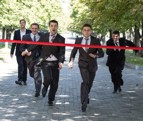 Business race. Business people are crossing red finish tape