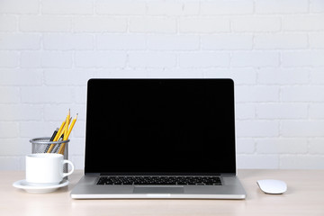 Modern laptop on table, on white wall background