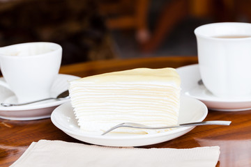 White cake on white dish with fork, napkin on table