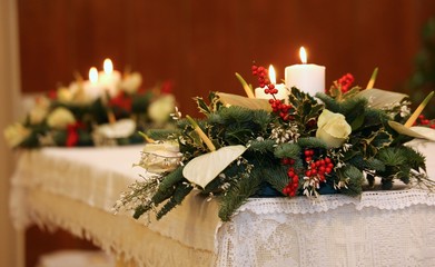 two bunches of flowers and two lit candles on the altar
