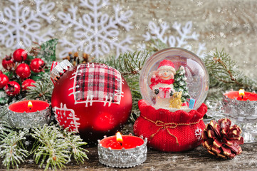 Christmas decorations of candles and snow globe with snowmen