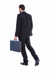Businessman walking while holding briefcase
